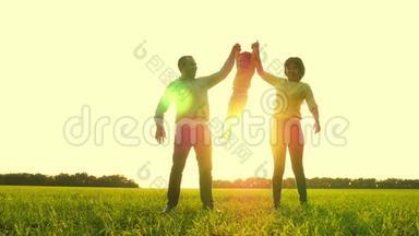 快乐的<strong>爸爸妈妈</strong>抱着一个孩子`她的手举起来，在夕阳的映衬下.. 幸福的概念